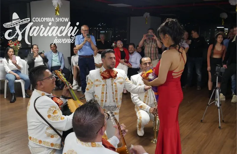 Músico mariachi de rodillas cantando en un aniversario en Barranquilla
